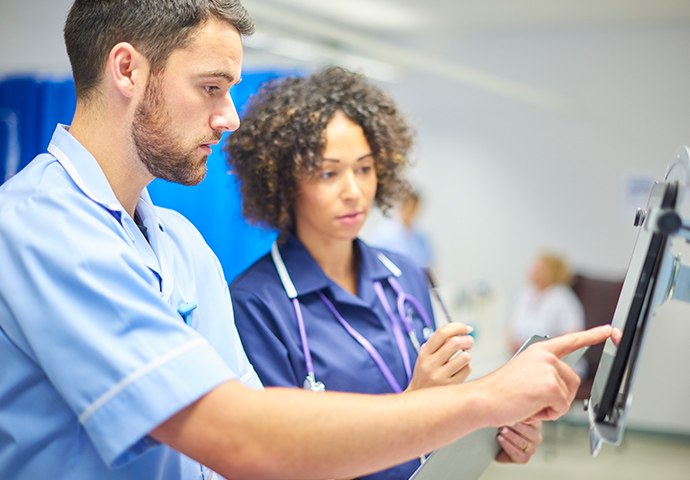 two medical professionals looking at a screen