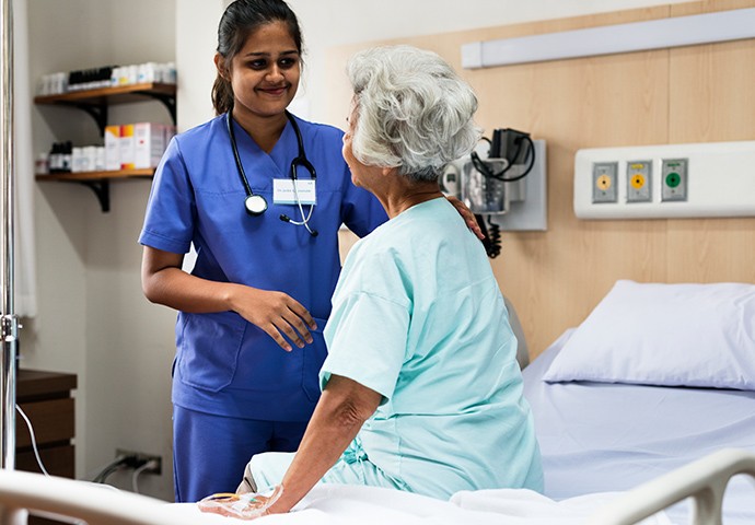 nurse helping a patient in a hospital setting